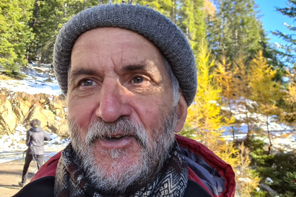Ich geh als Pfarrer gerne Caritassammeln. Ich lerne die Menschen kennen, die ich nicht in der Kirche antreffe. Ich sehe auch Nöte von Menschen, denen ich umgekehrt Hilfe anbieten kann. Ich kommʼ ins Gespräch und erbitte den Segen für sie. Portrait eines Mannes mit Wollmütze
