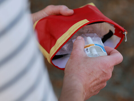 Eine Person holt ein Naloxon-Nasenspray aus einer Tasche.